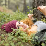 smiley-woman-laying-grass_23-2148918897
